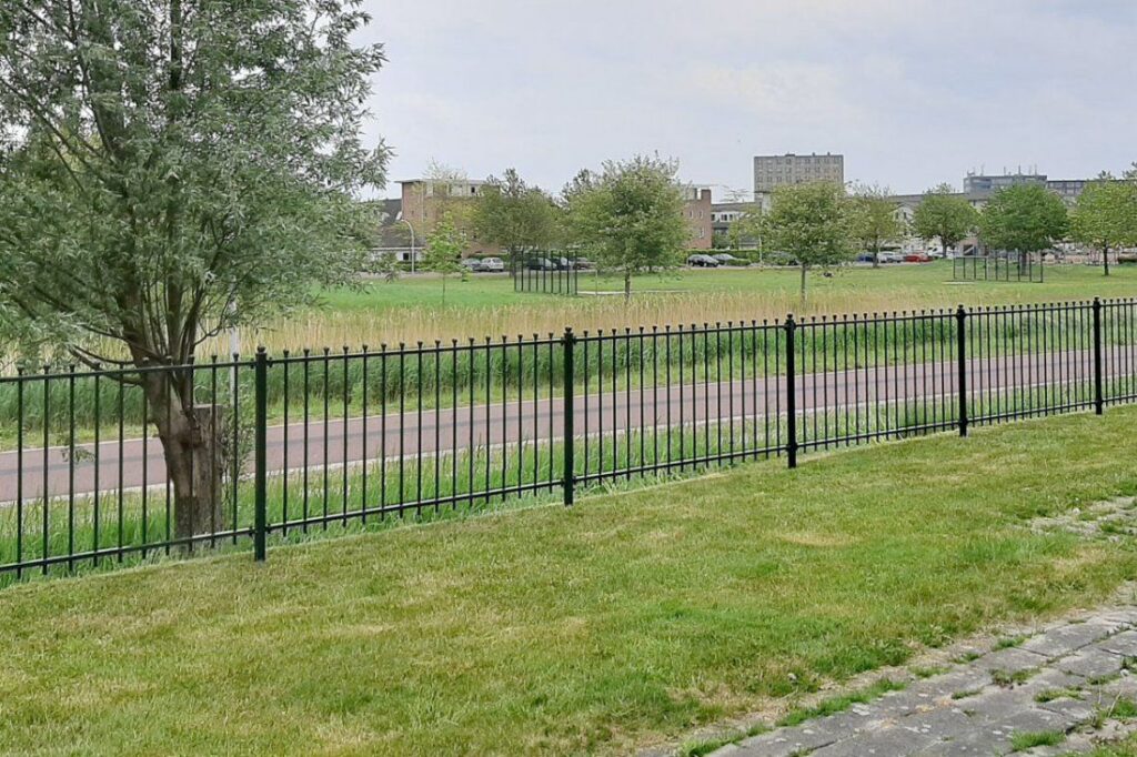 Sierhekwerk als erfgrens met uitzicht over het weiland