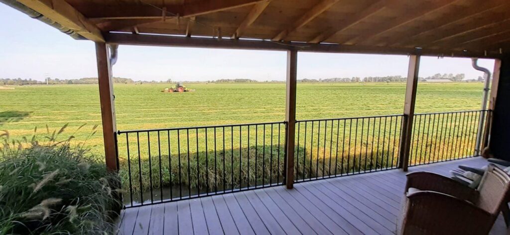 Sierhekwerk langs een veranda met uitzicht op het weiland